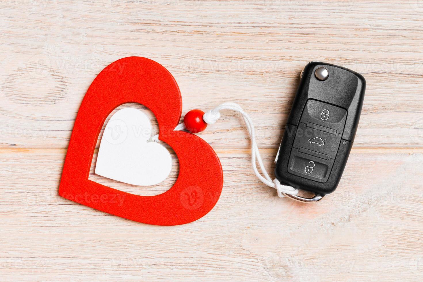 Top view of a present for Valentine's Day on wooden background. Close up of car key and heart. Surprise concept for a holiday photo