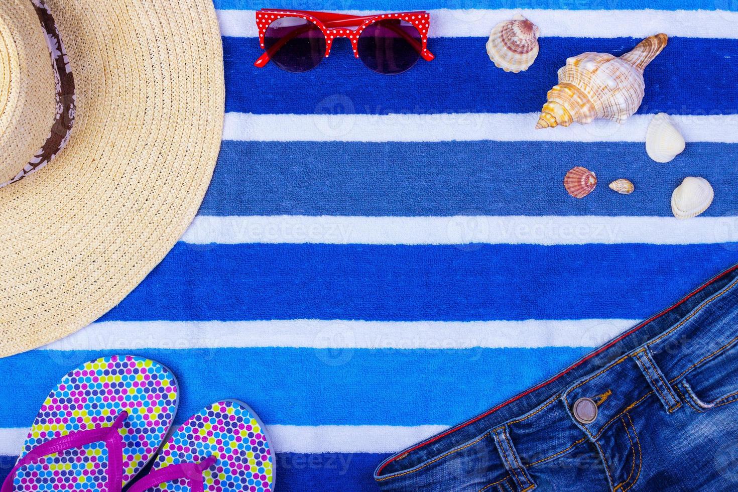 Straw Beach Woman's Hat Sun Glasses Top View Seashell Shorts Flip flops with space for text. photo