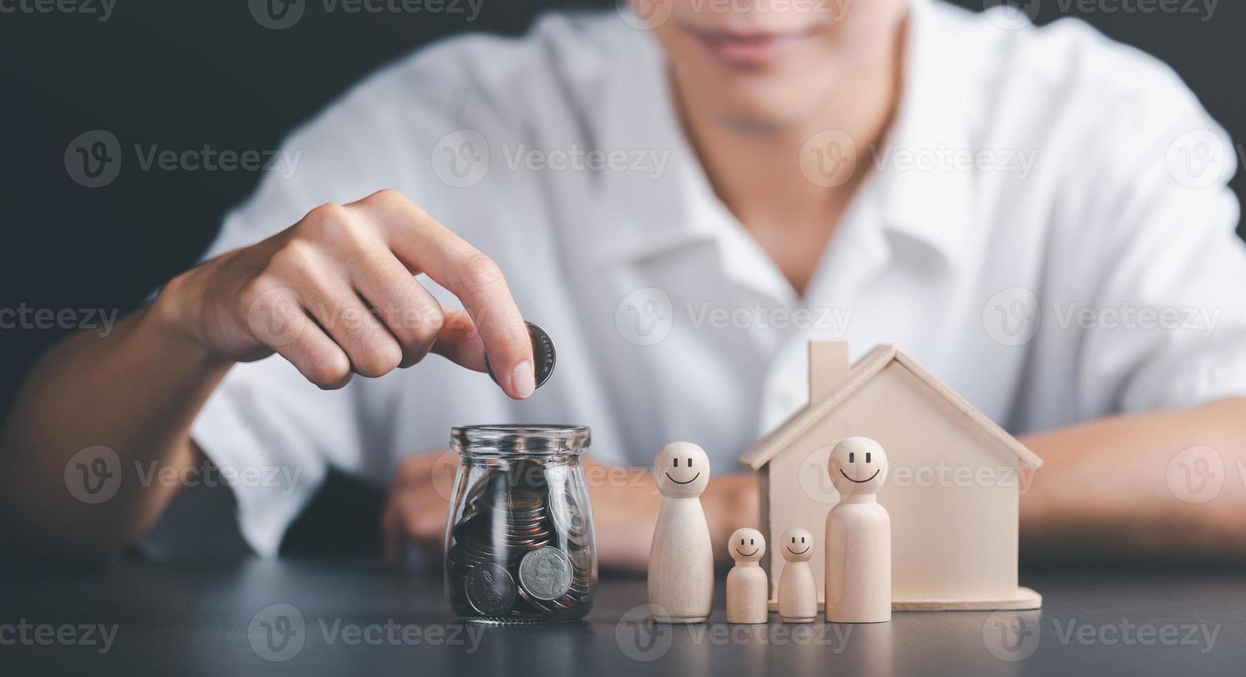 Man puts coins into a glass jar,concept of a loan for housing,Approval of credit for the purchase of real estate,business and finance concept,home loan refinancing,Financial wealth management photo