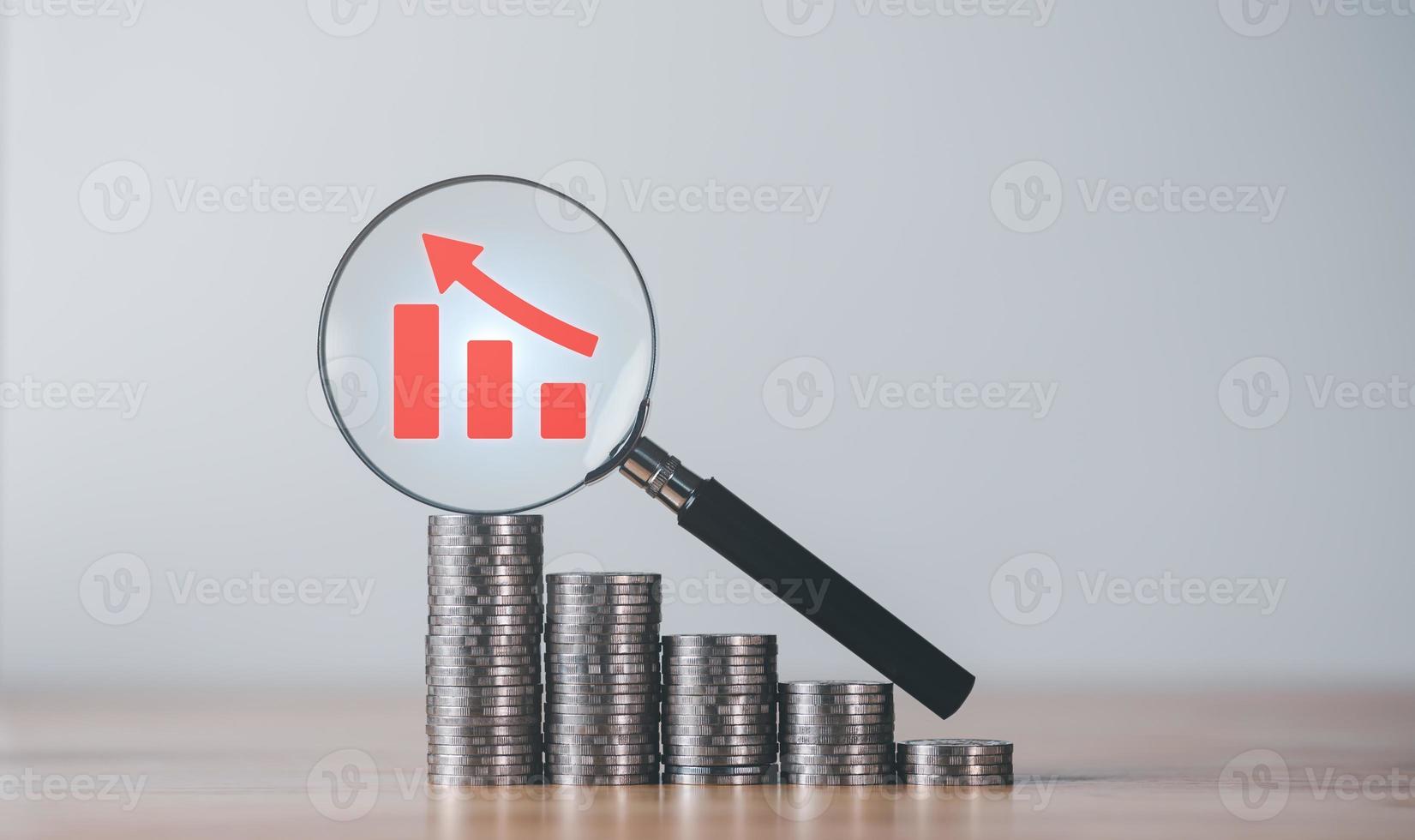 Stacks of coins, magnifying glass, and graph showing profit increase,business growth,concept of progress in development financial performance and investment,with business strategies for future goals photo