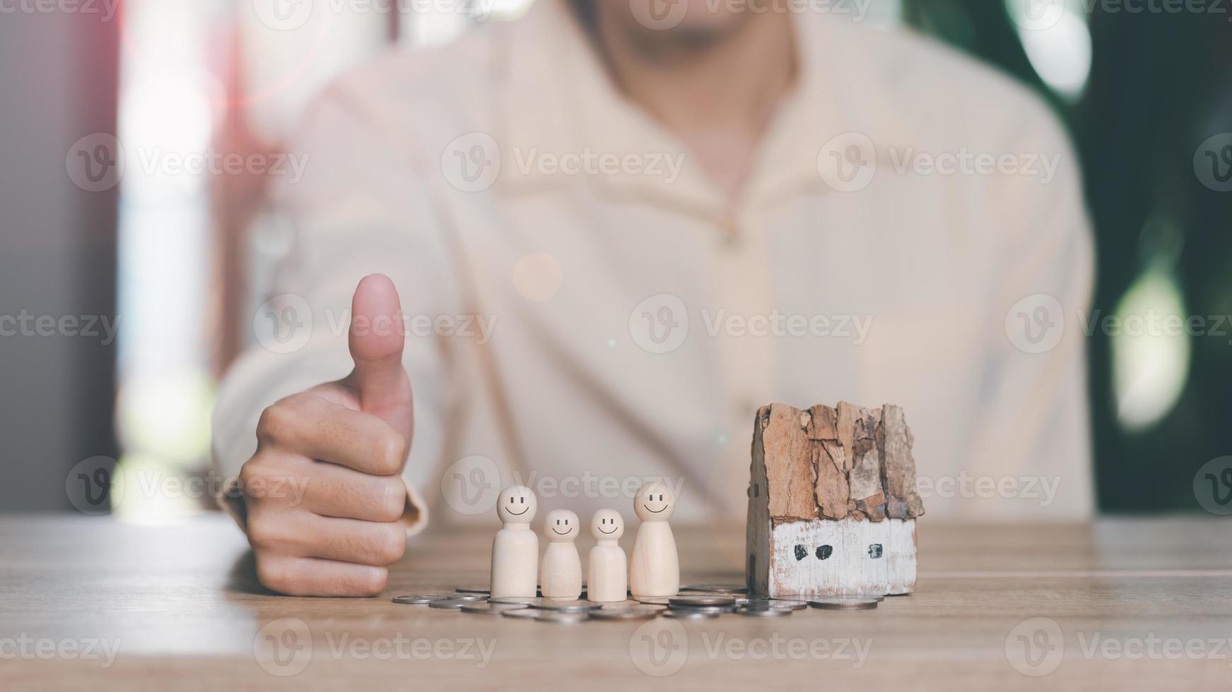Male hands, wooden dolls, and model houses,Concept of protection and safety protection,insurance management planning To ensure both health and financial safety,Property and Family Risk Reduction photo