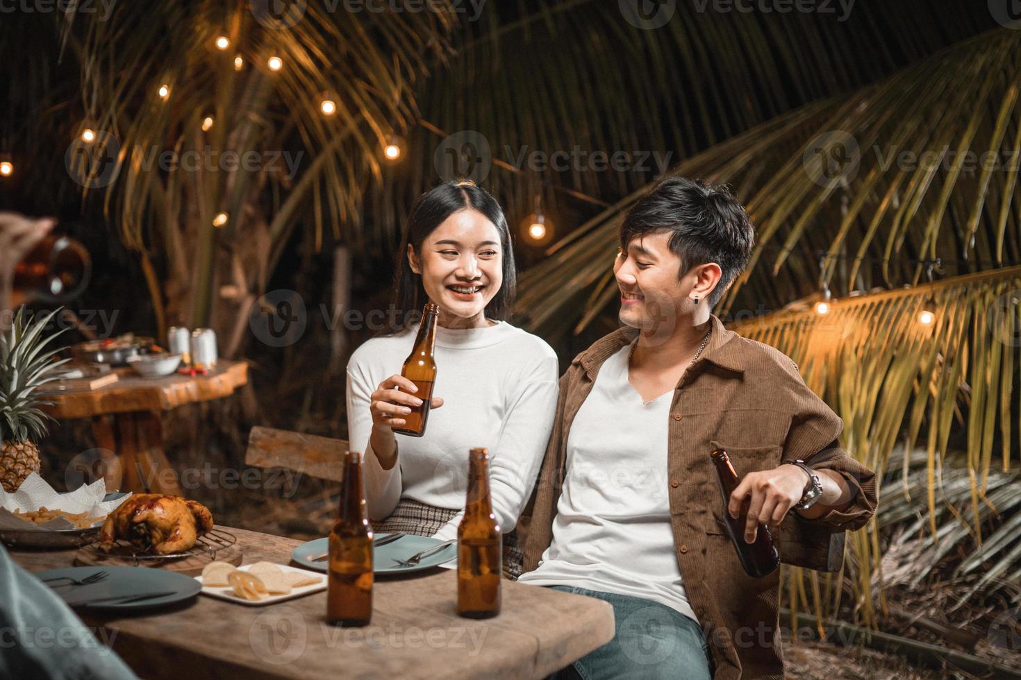 joven pareja asiática brindando con cerveza en una fiesta en el jardín foto