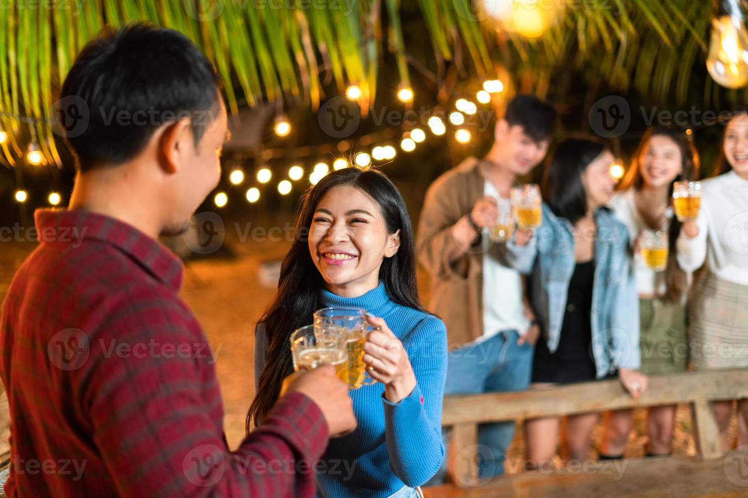 pareja feliz bebiendo cerveza con amigos en la fiesta foto