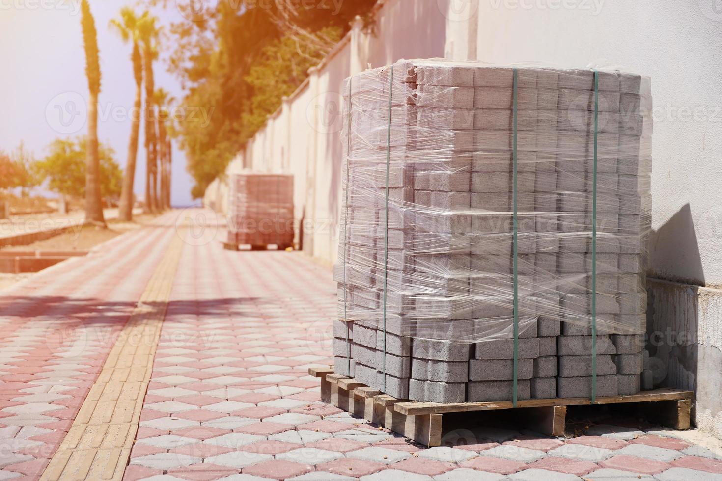 Paving stones on wooden pallet on the street sidewalk photo