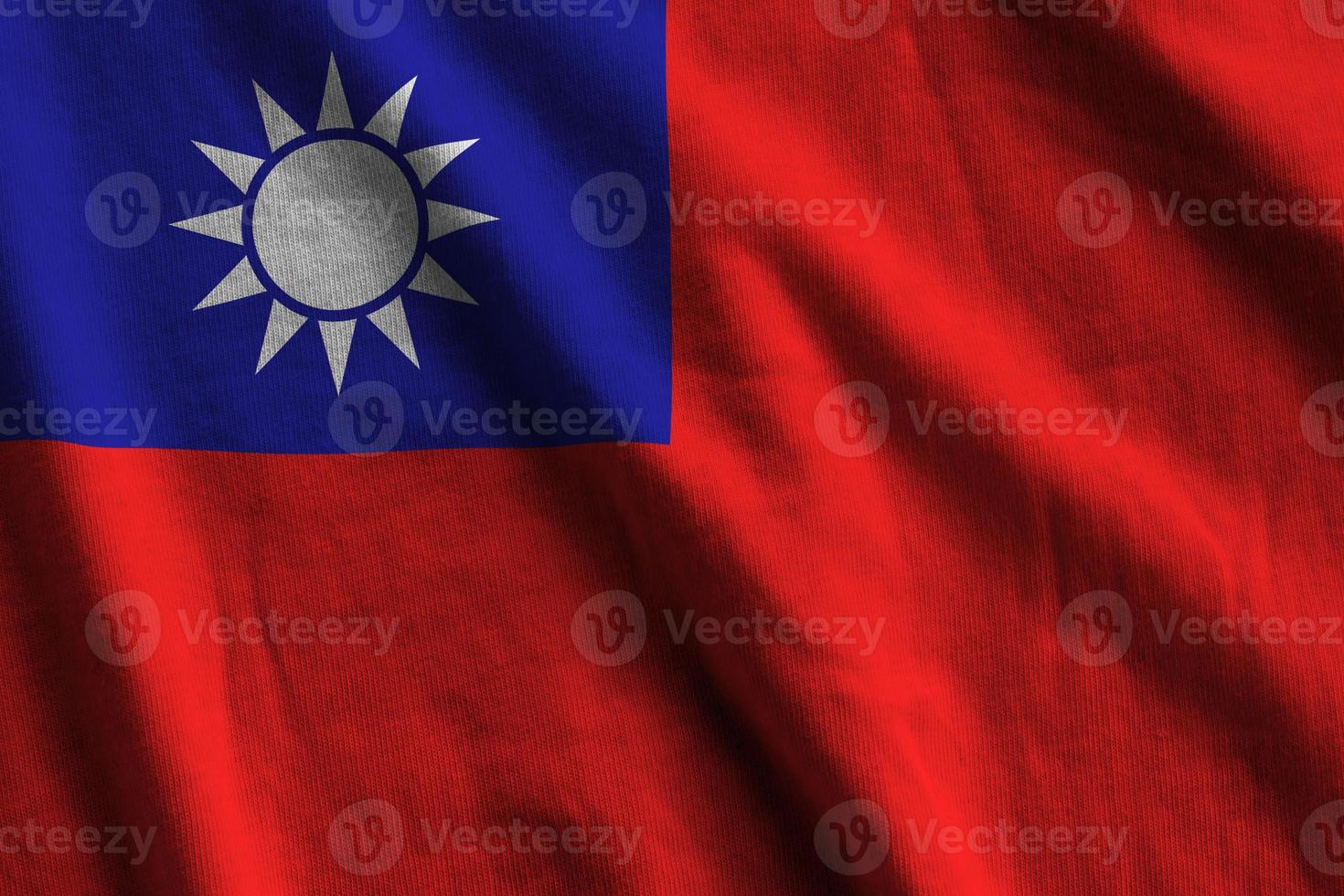 Taiwan flag with big folds waving close up under the studio light indoors. The official symbols and colors in banner photo
