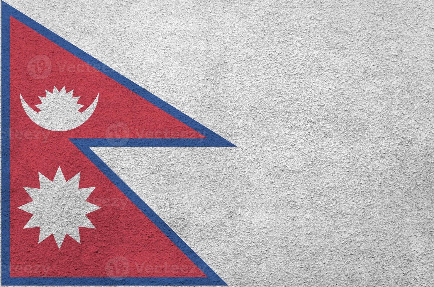 Nepal flag depicted in bright paint colors on old relief plastering wall. Textured banner on rough background photo