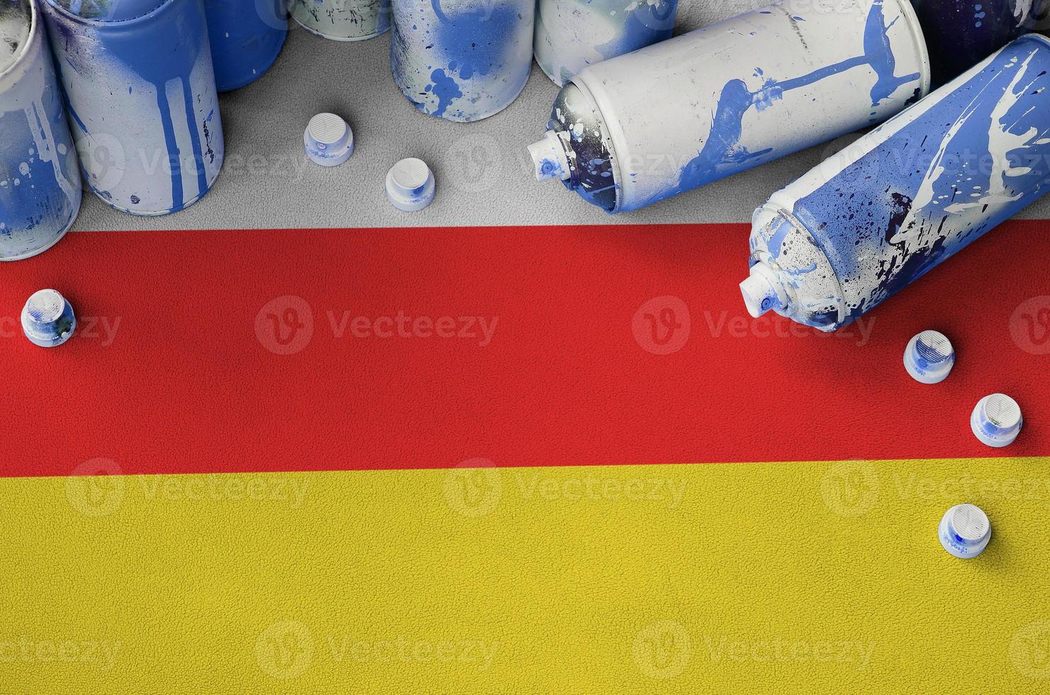 South Ossetia flag and few used aerosol spray cans for graffiti painting. Street art culture concept photo