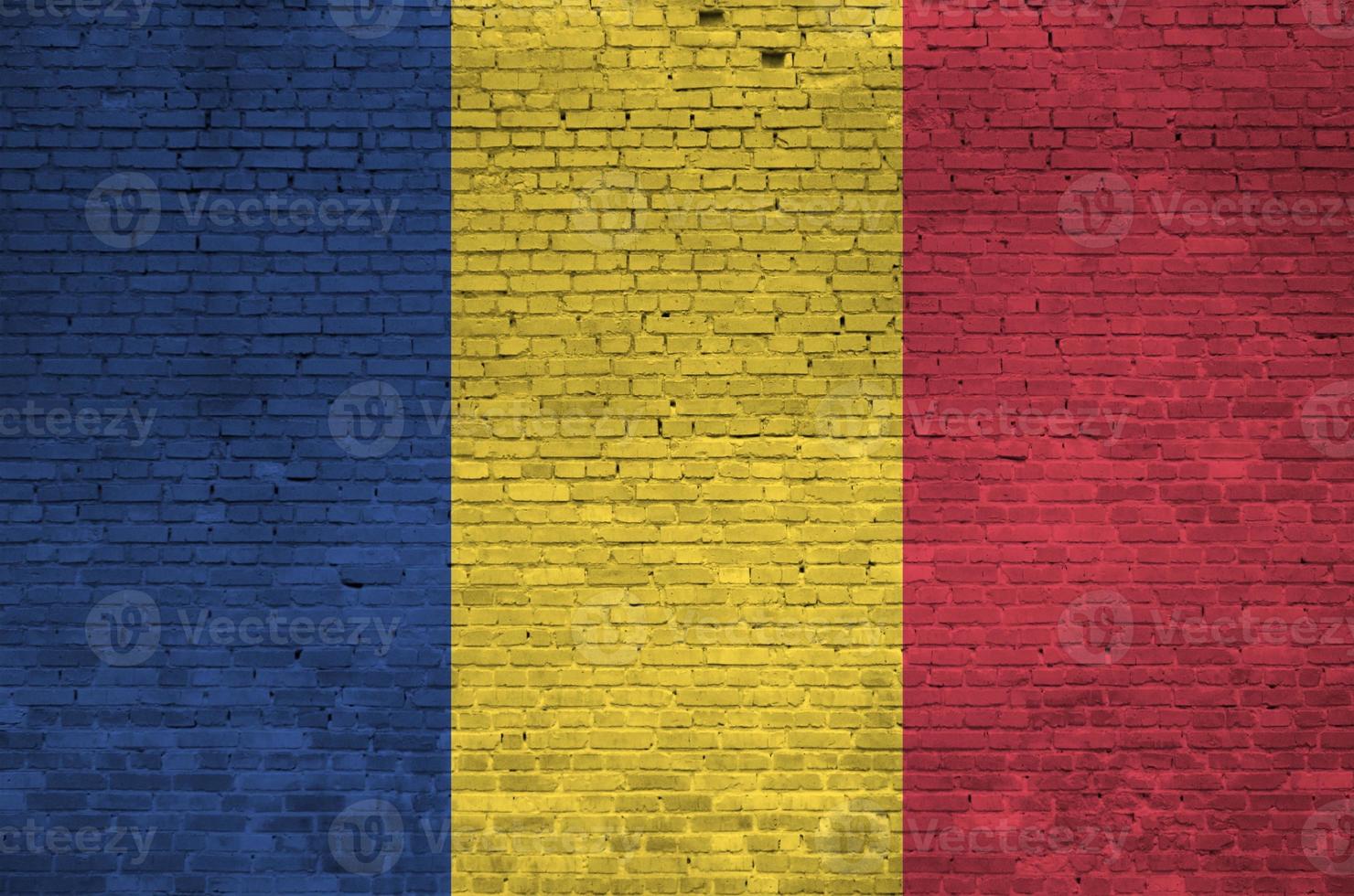 Romania flag depicted in paint colors on old brick wall. Textured banner on big brick wall masonry background photo
