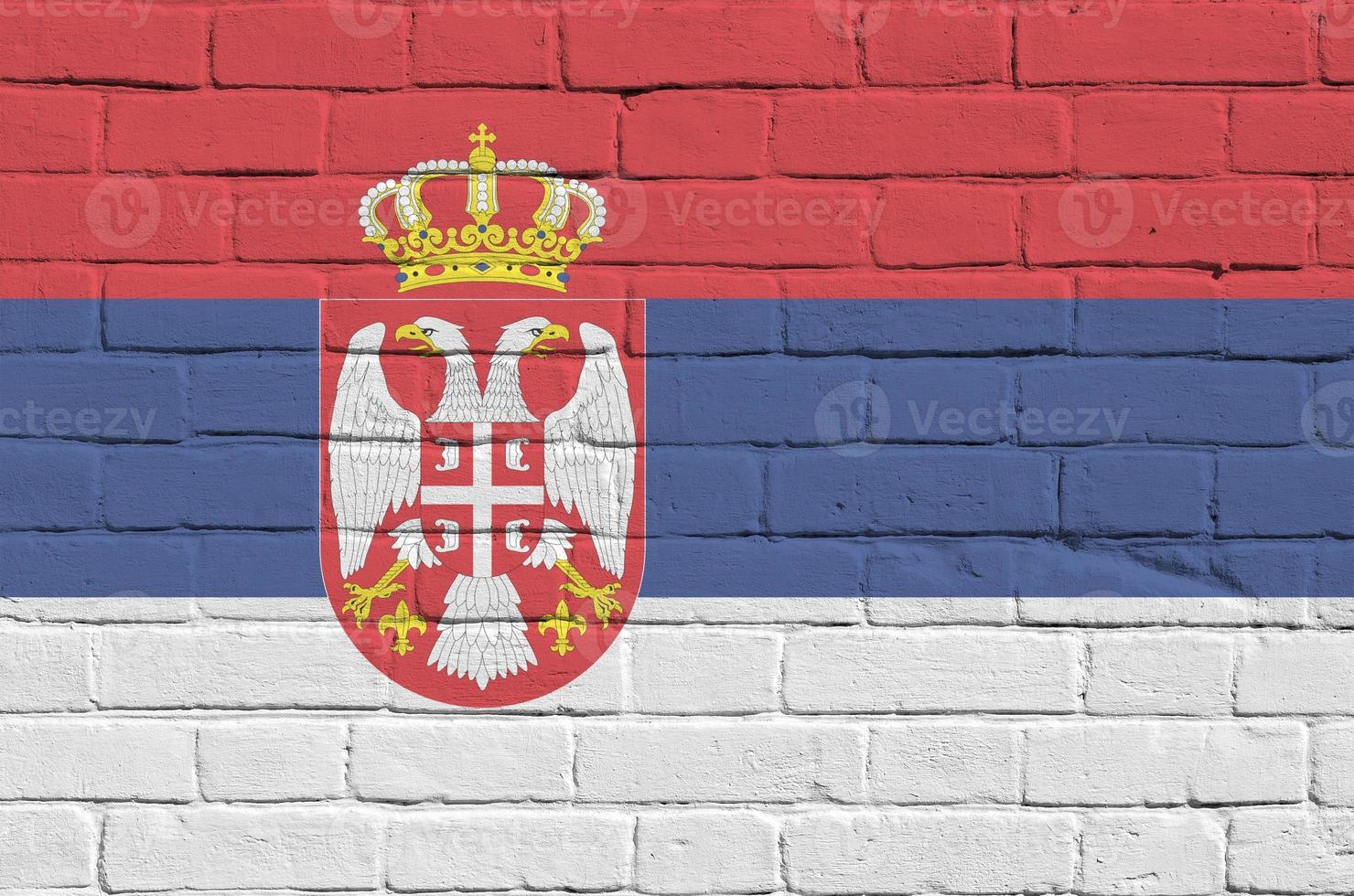 bandera de serbia representada en colores de pintura en la pared de ladrillo antiguo. banner texturizado sobre fondo de mampostería de pared de ladrillo grande foto