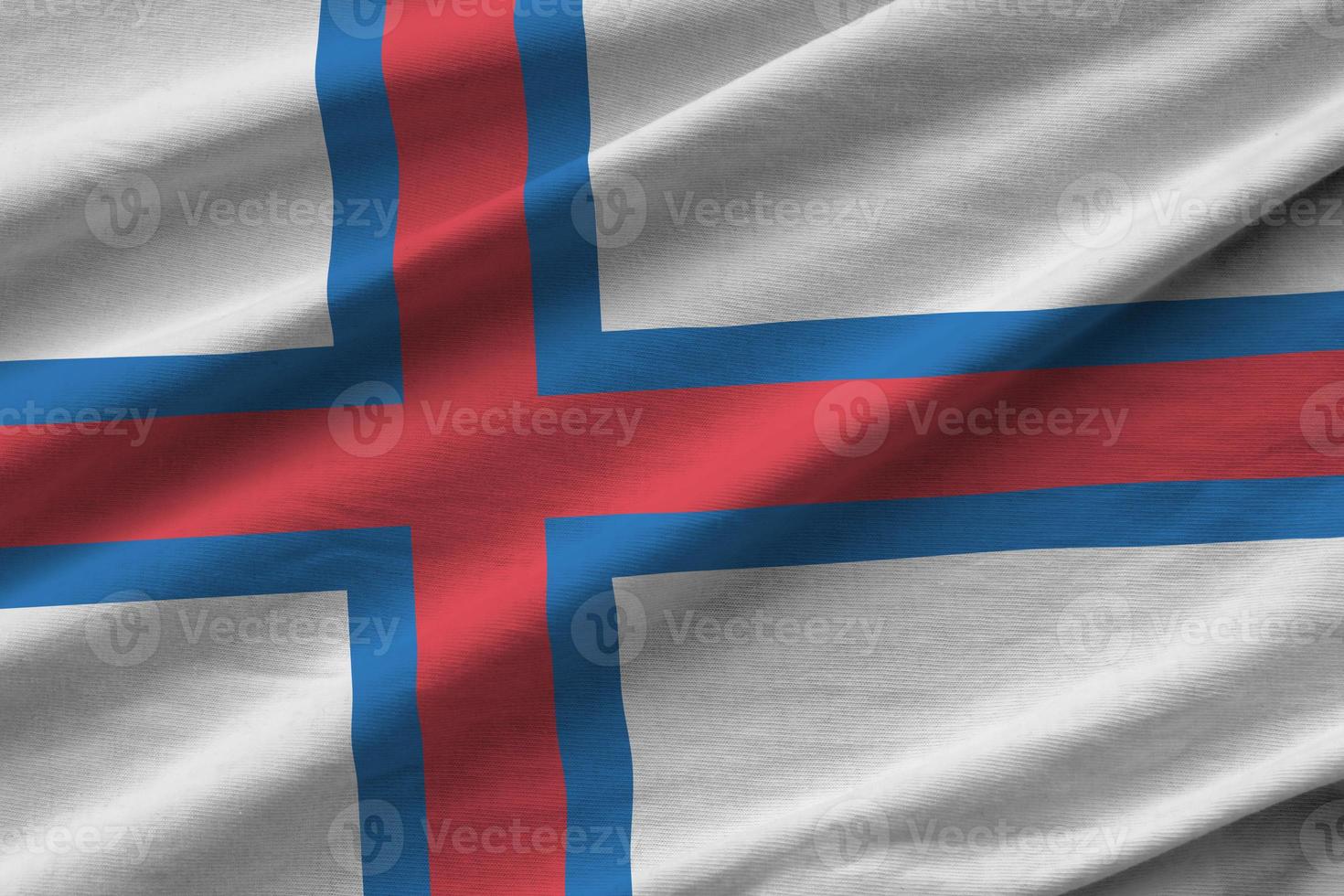 Faroe islands flag with big folds waving close up under the studio light indoors. The official symbols and colors in banner photo