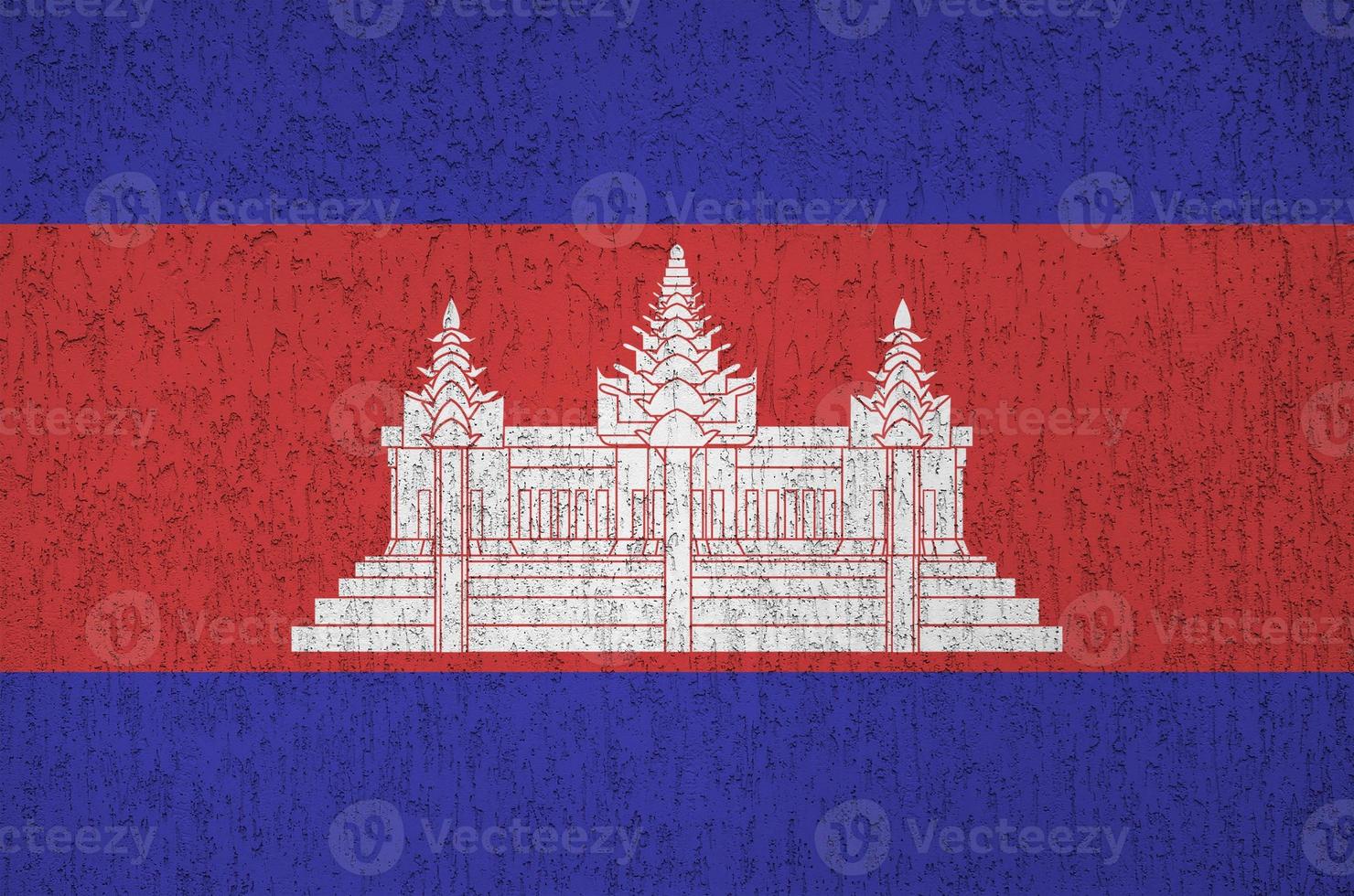 Cambodia flag depicted in bright paint colors on old relief plastering wall. Textured banner on rough background photo