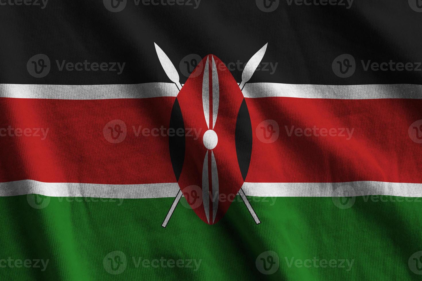 Kenya flag with big folds waving close up under the studio light indoors. The official symbols and colors in banner photo
