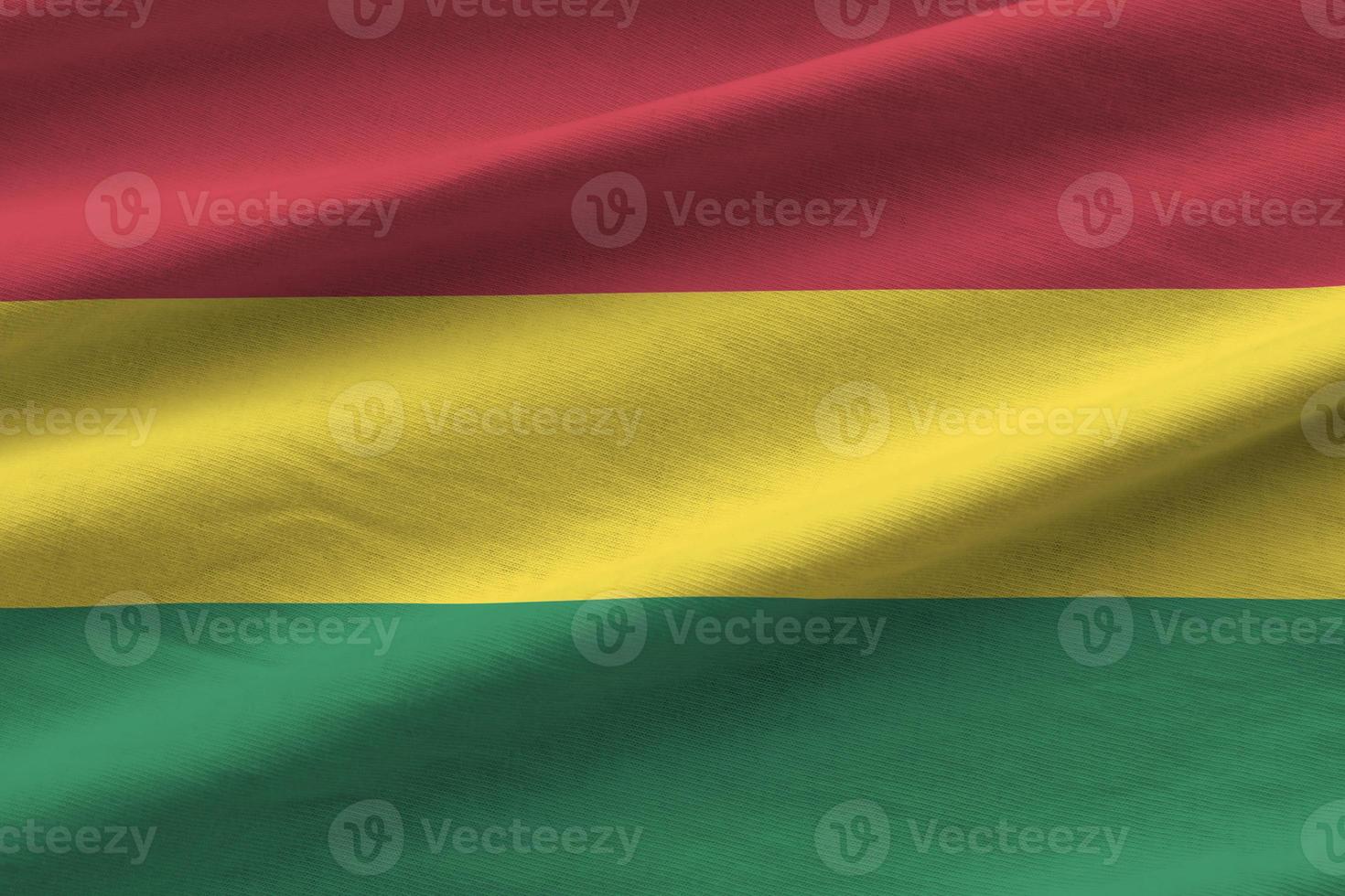 Bolivia flag with big folds waving close up under the studio light indoors. The official symbols and colors in banner photo
