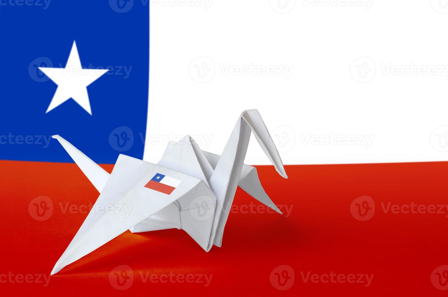 Chile flag depicted on paper origami crane wing. Handmade arts concept photo
