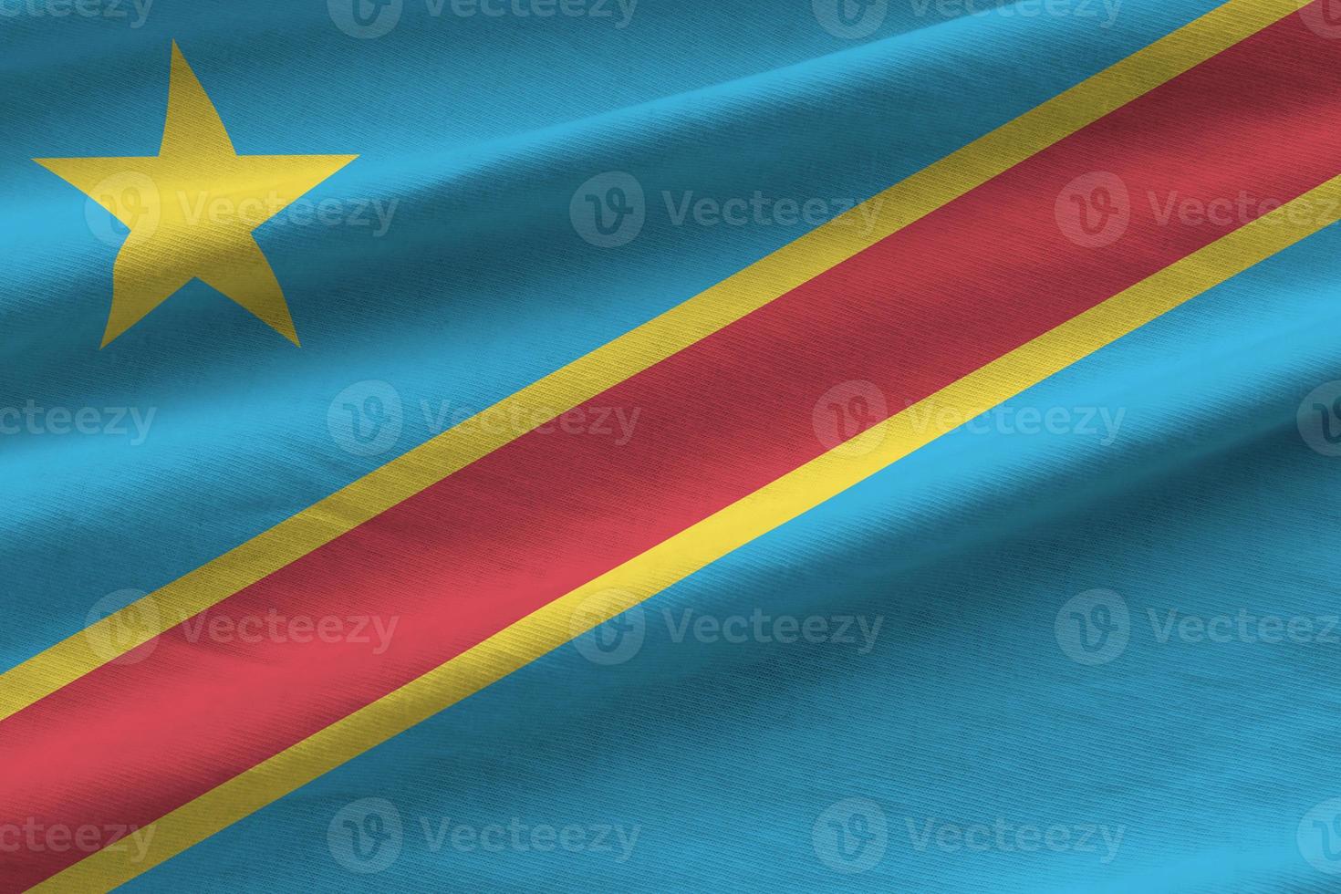 Democratic Republic of the Congo flag with big folds waving close up under the studio light indoors. The official symbols and colors in banner photo