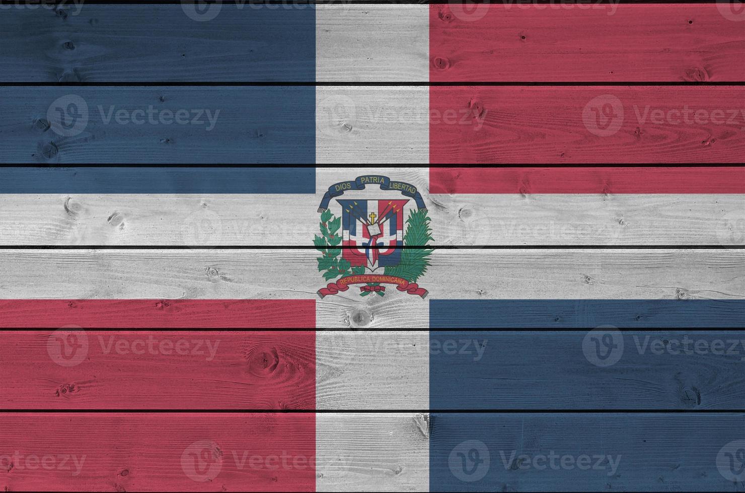 Dominican Republic flag depicted in bright paint colors on old wooden wall. Textured banner on rough background photo