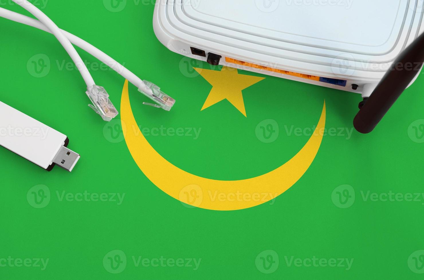 Mauritania flag depicted on table with internet rj45 cable, wireless usb wifi adapter and router. Internet connection concept photo