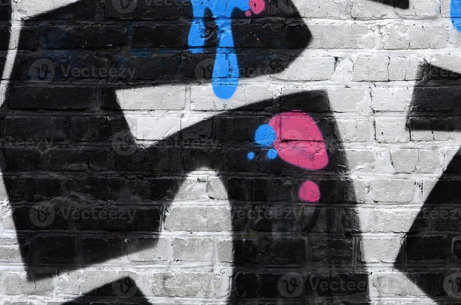 Fragment of graffiti drawings. The old wall decorated with paint stains in the style of street art culture. Colored background texture photo