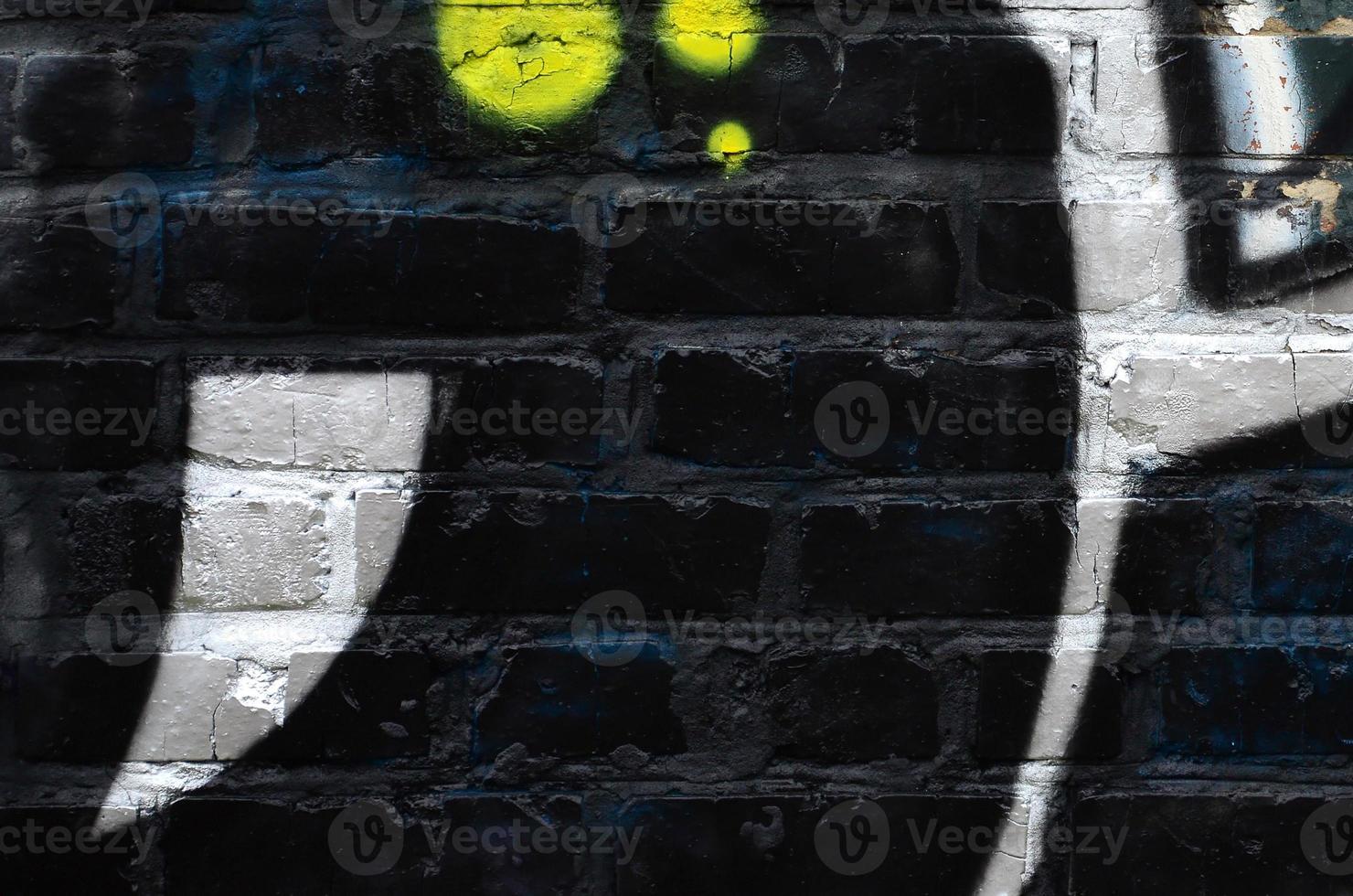 Fragment of graffiti drawings. The old wall decorated with paint stains in the style of street art culture. Colored background texture photo