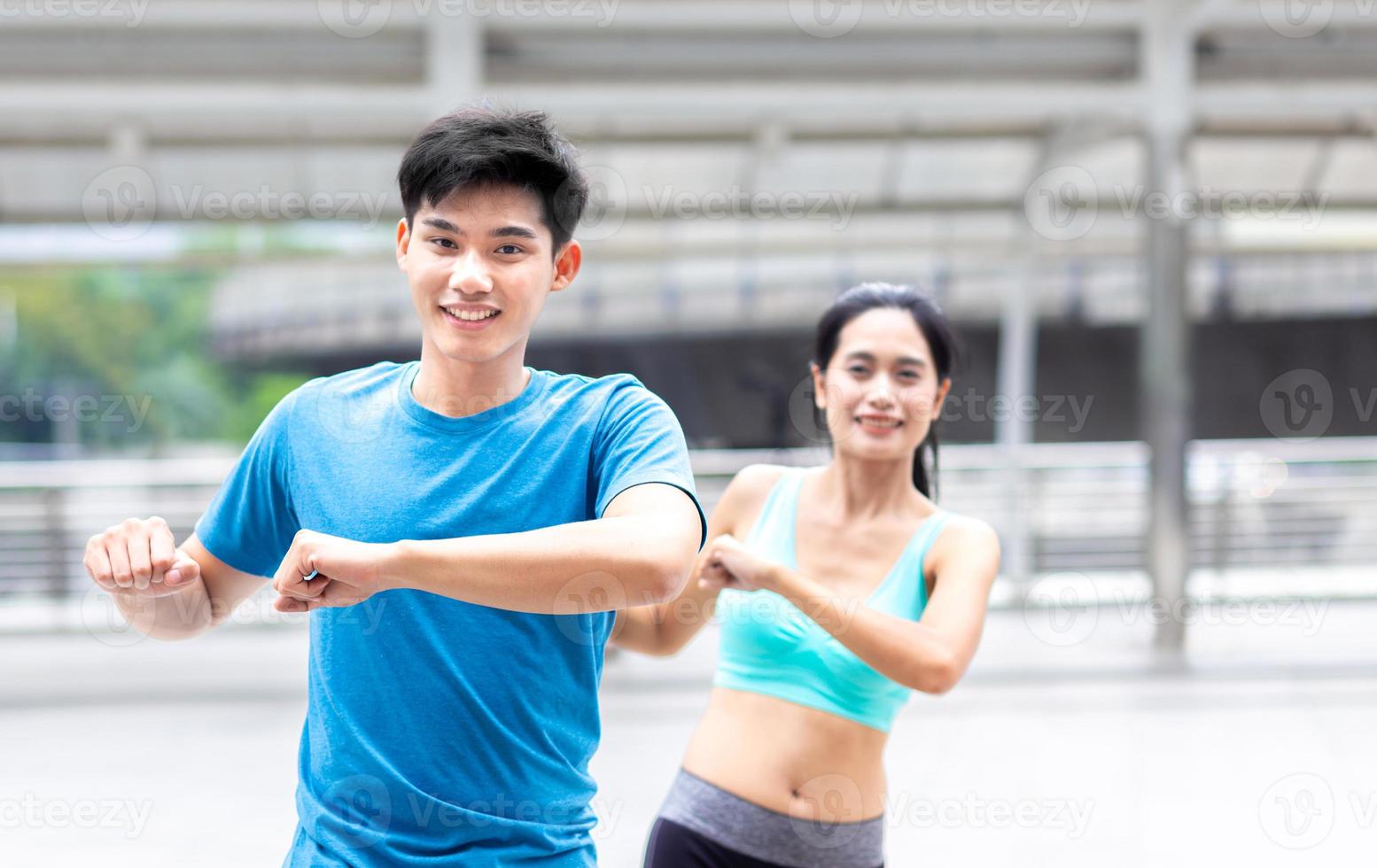 feliz y saludable hombre y mujer atleta corredor ejercicio calentar juntos antes de trotar al aire libre y hacer ejercicio o correr en la ciudad foto