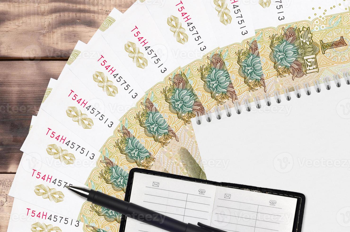 1 Chinese yuan bills fan and notepad with contact book and black pen. Concept of financial planning and business strategy photo