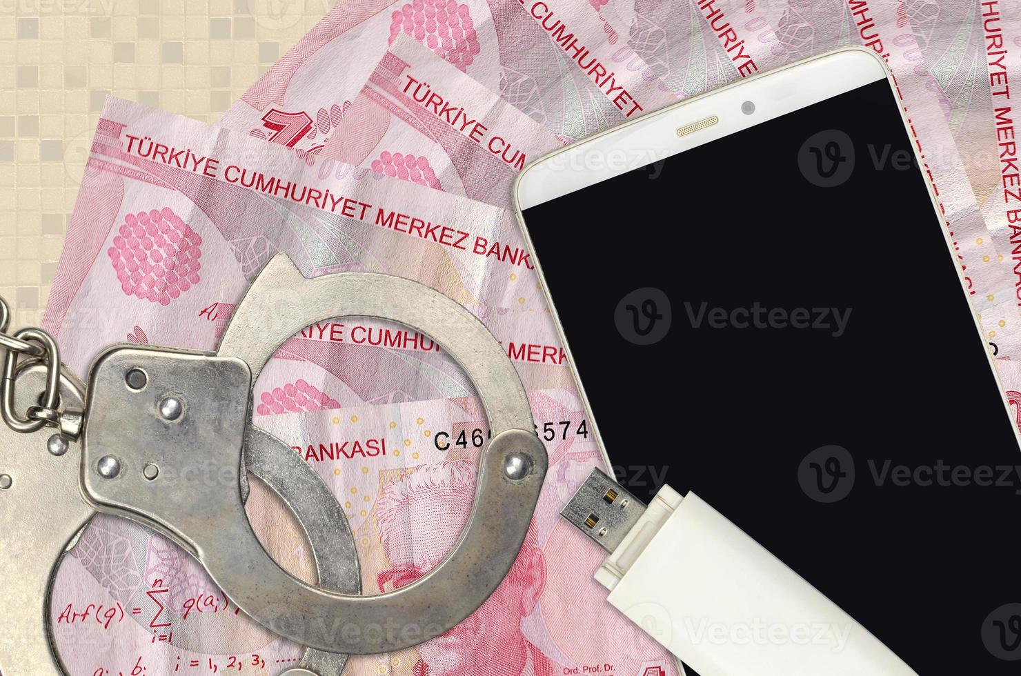 Billetes de 10 liras turcas y smartphone con esposas policiales. concepto de ataques de phishing de piratas informáticos, estafa ilegal o distribución blanda de malware foto
