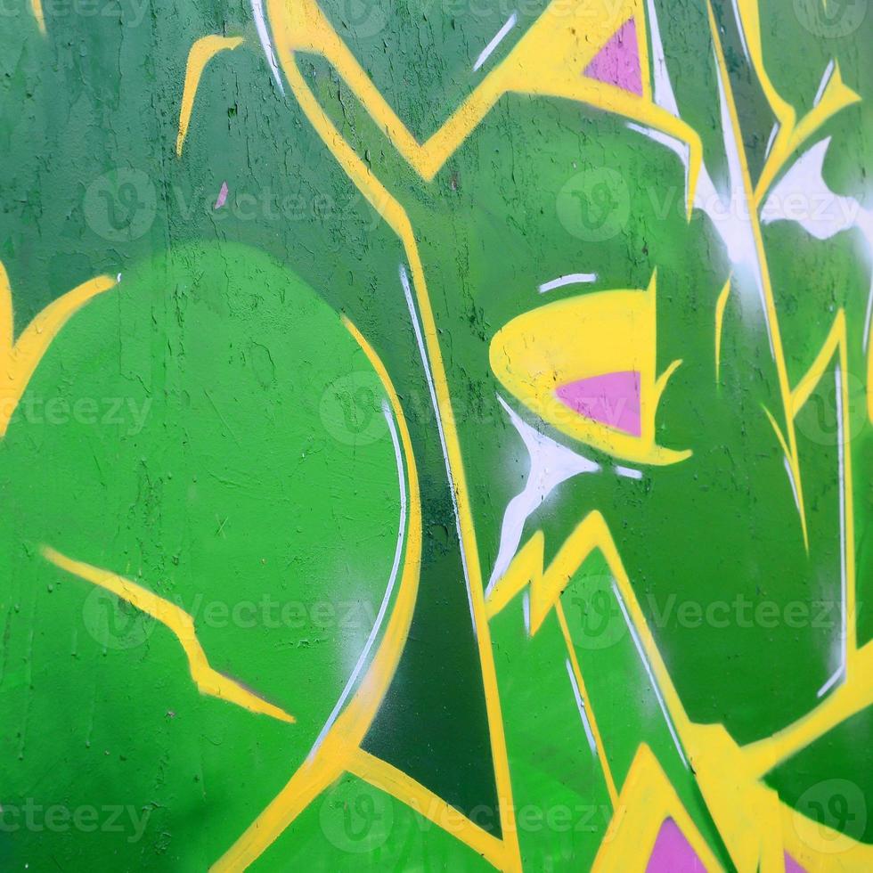 Fragment of graffiti drawings. The old wall decorated with paint stains in the style of street art culture. Colored background texture photo