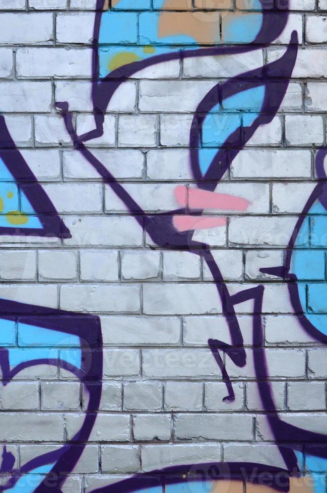 Fragment of graffiti drawings. The old wall decorated with paint stains in the style of street art culture. Colored background texture photo