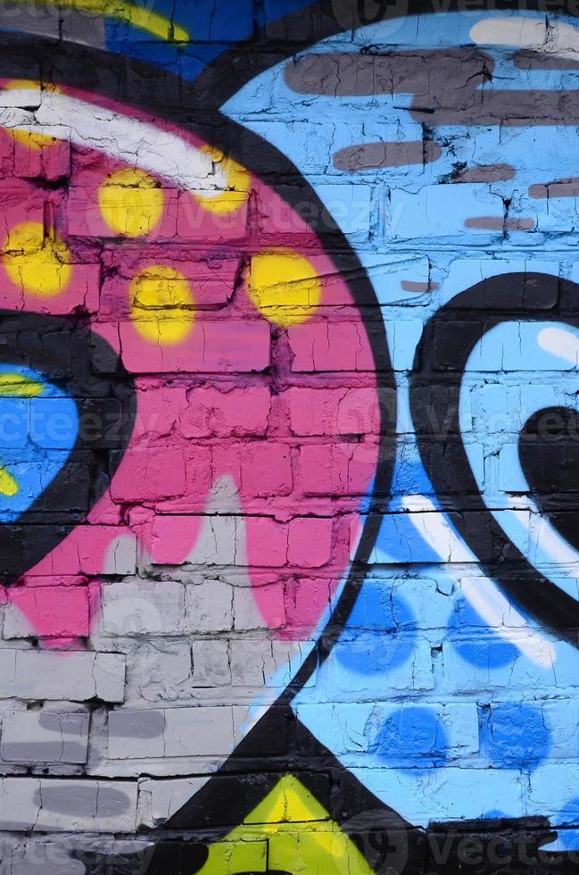 Fragment of graffiti drawings. The old wall decorated with paint stains in the style of street art culture. Colored background texture photo