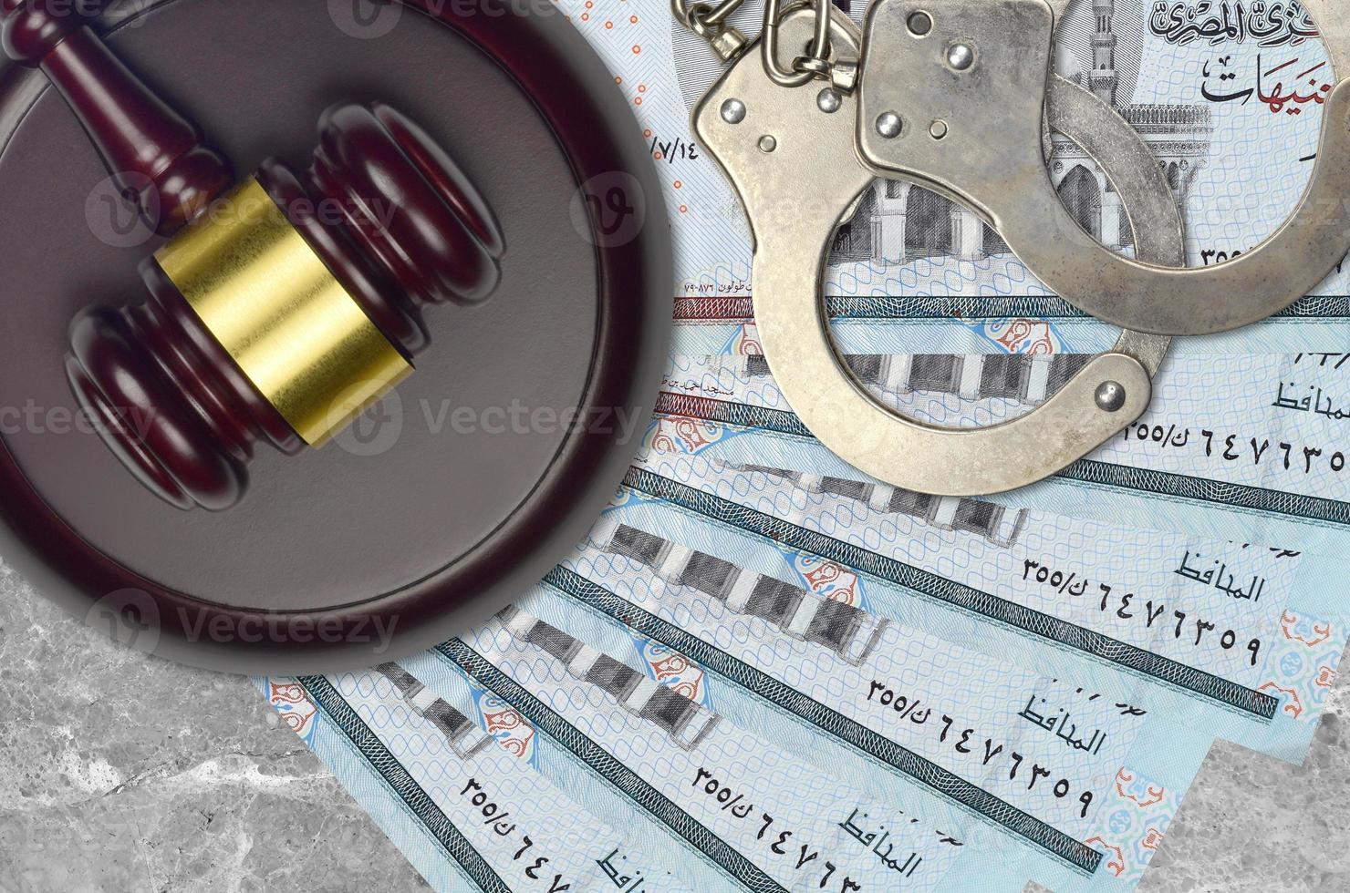 5 Egyptian pounds bills and judge hammer with police handcuffs on court desk. Concept of judicial trial or bribery. Tax avoidance photo