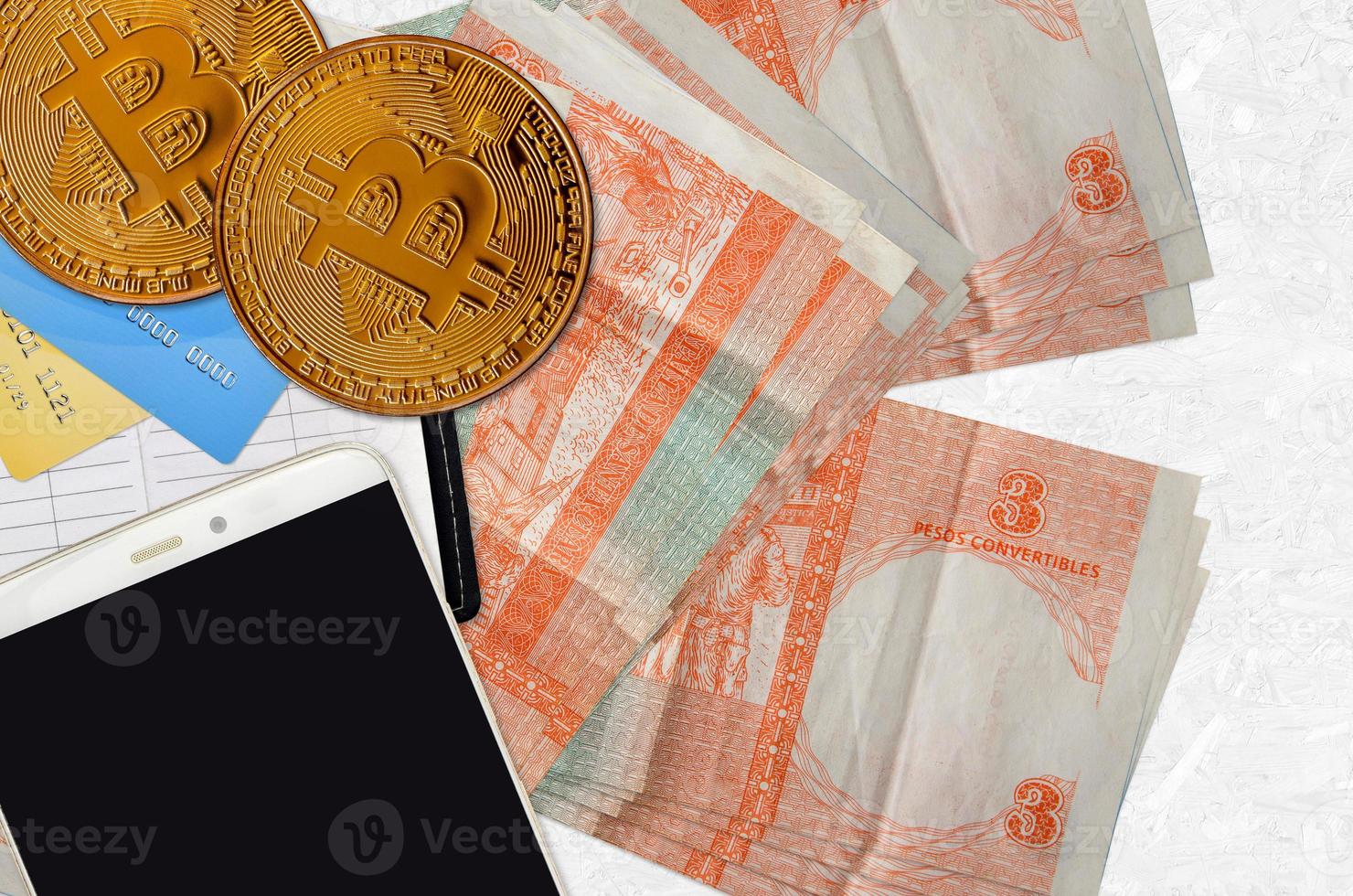 3 cuban pesos convertibles bills and golden bitcoins with smartphone and credit cards. Cryptocurrency investment concept. Crypto mining or trading photo