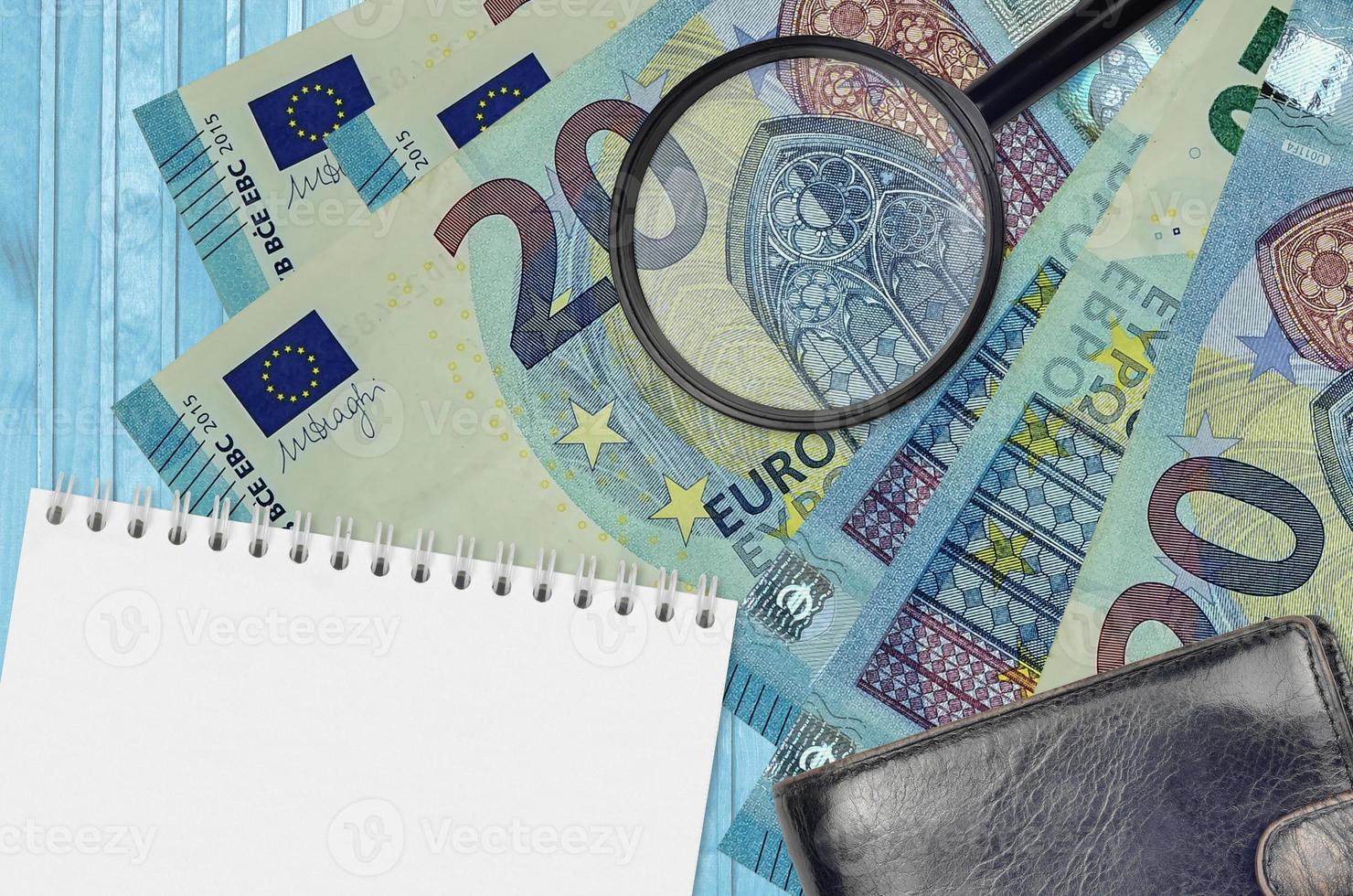 20 euro bills and magnifying glass with black purse and notepad. Concept of counterfeit money. Search for differences in details on money bills to detect fake photo