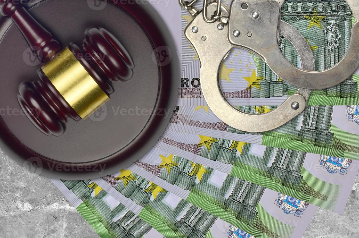 100 Euro bills and judge hammer with police handcuffs on court desk. Concept of judicial trial or bribery. Tax avoidance photo
