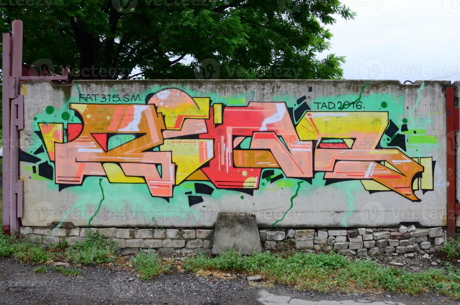 Full and acomplished graffiti artwork. The old wall decorated with paint stains in the style of street art culture. Colored background texture photo