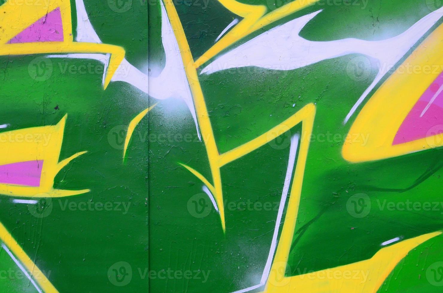 Fragment of graffiti drawings. The old wall decorated with paint stains in the style of street art culture. Colored background texture photo