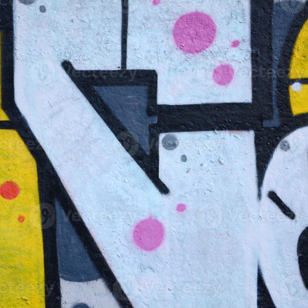 Fragment of graffiti drawings. The old wall decorated with paint stains in the style of street art culture. Colored background texture photo