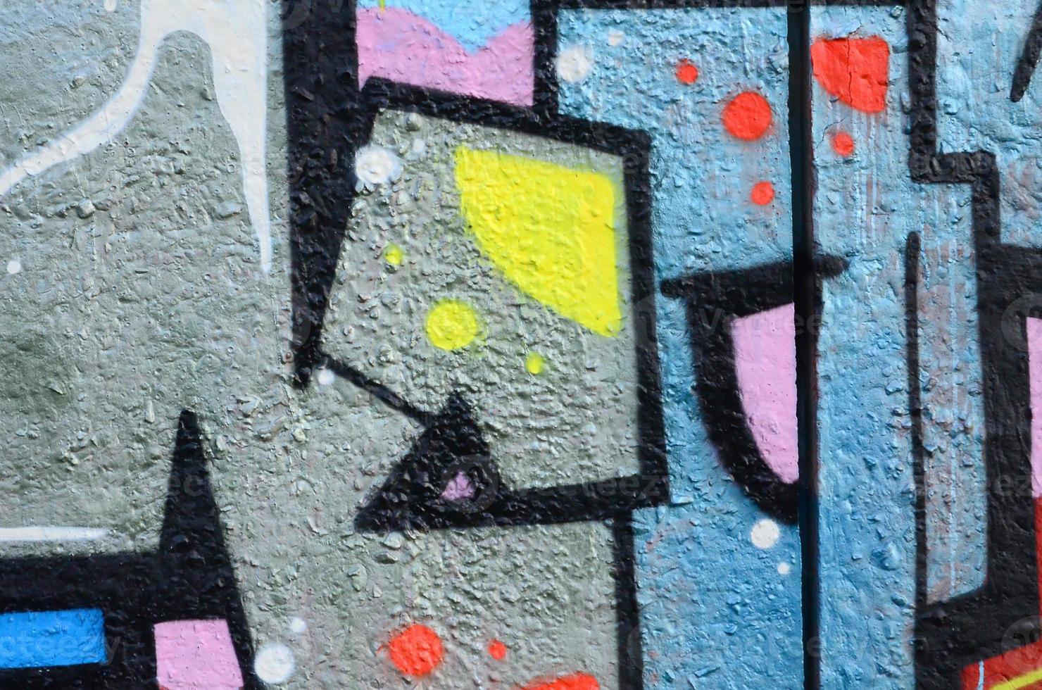 Fragment of graffiti drawings. The old wall decorated with paint stains in the style of street art culture. Colored background texture photo