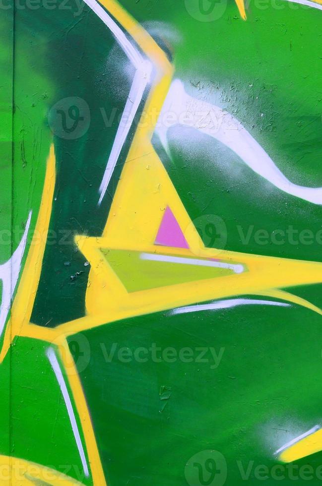 Fragment of graffiti drawings. The old wall decorated with paint stains in the style of street art culture. Colored background texture photo