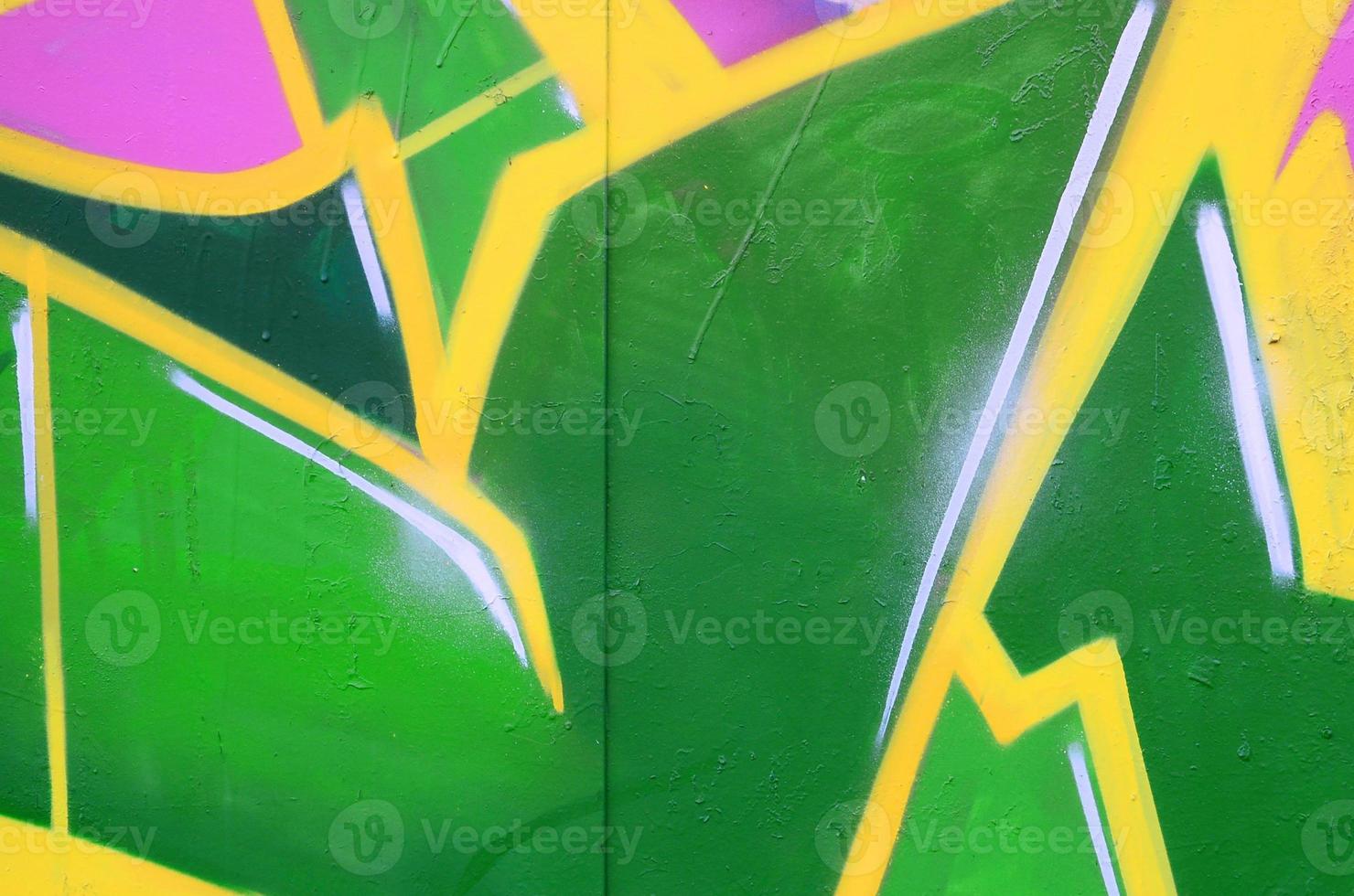 Fragment of graffiti drawings. The old wall decorated with paint stains in the style of street art culture. Colored background texture photo