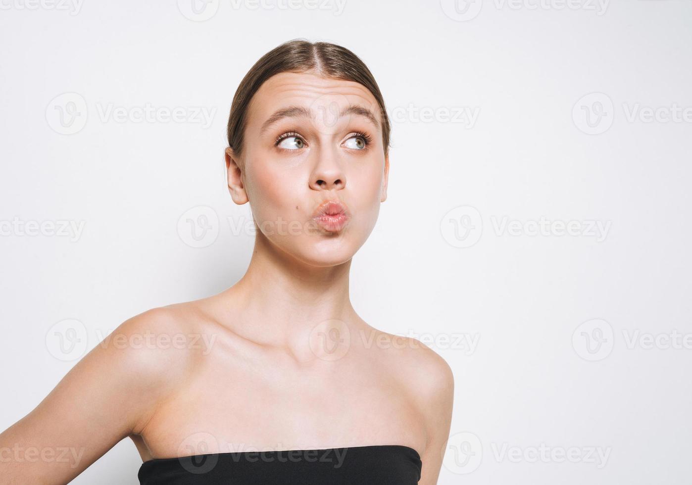 Beauty portrait of funny young girl with fresh skin tone showing kiss on white background isolated photo