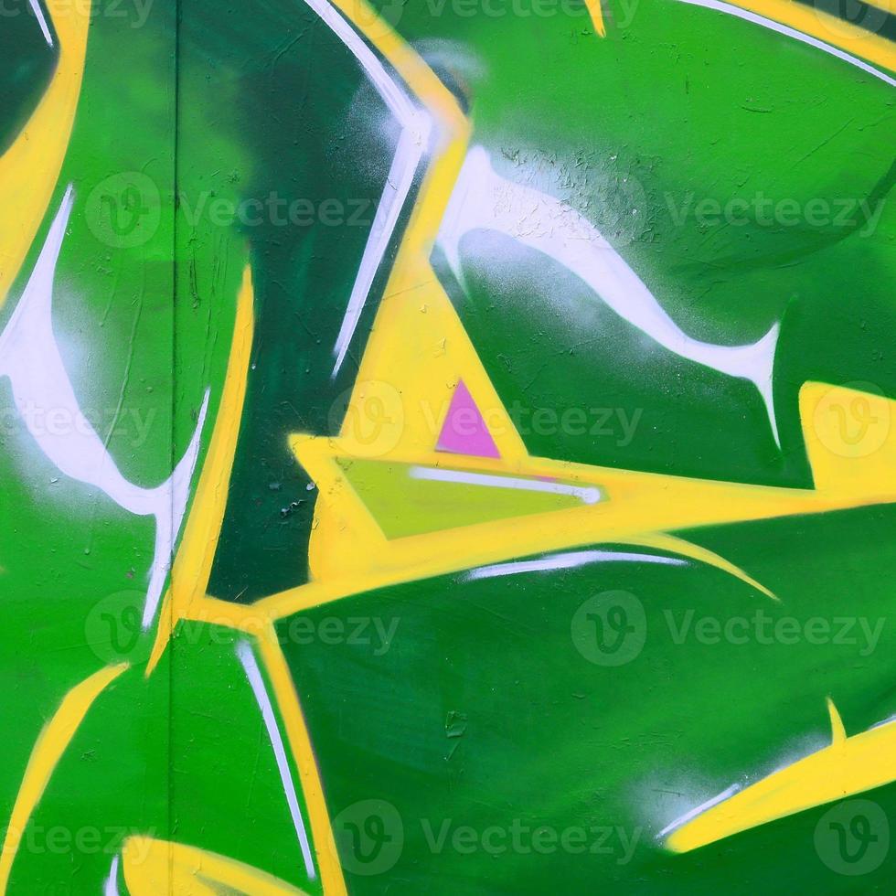 Fragment of graffiti drawings. The old wall decorated with paint stains in the style of street art culture. Colored background texture photo