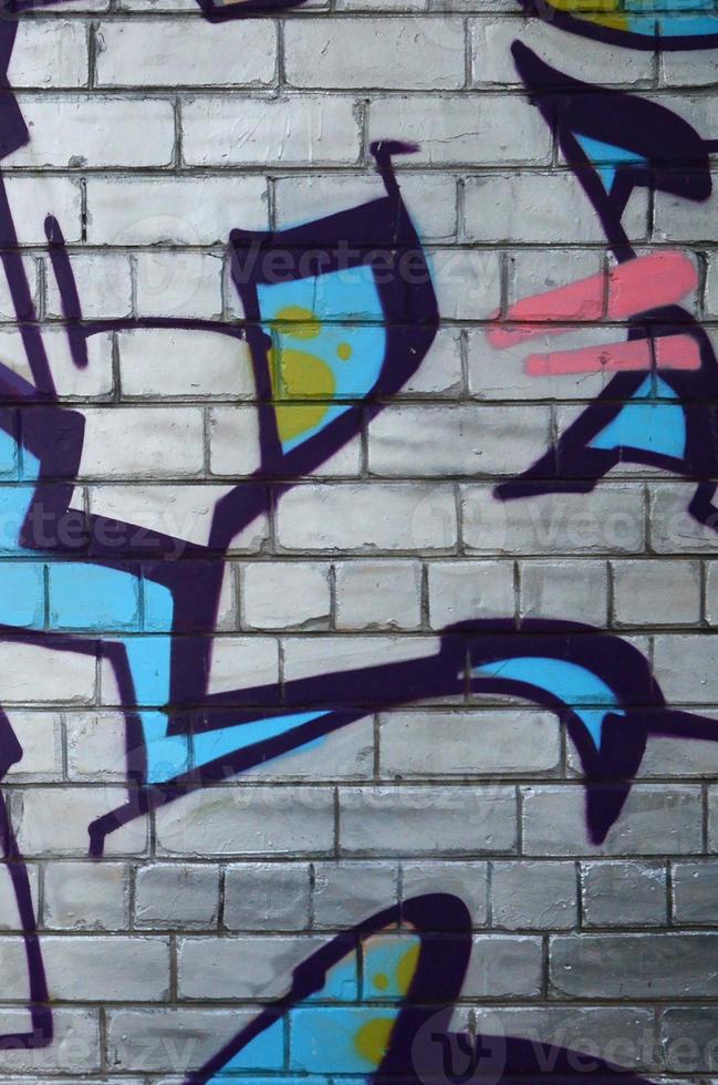 Fragment of graffiti drawings. The old wall decorated with paint stains in the style of street art culture. Colored background texture photo