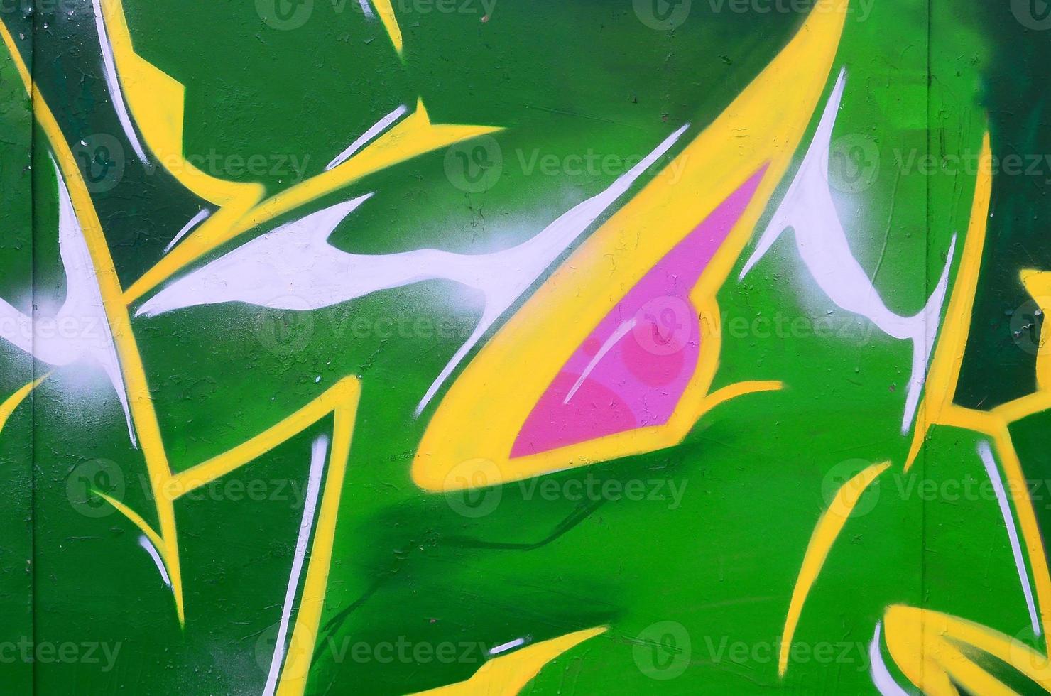 Fragment of graffiti drawings. The old wall decorated with paint stains in the style of street art culture. Colored background texture photo