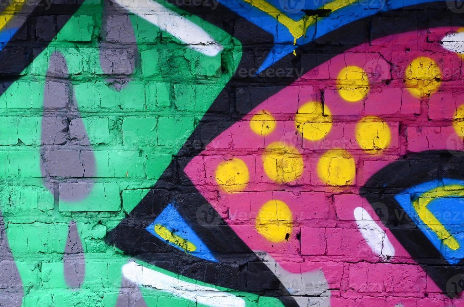 Fragment of graffiti drawings. The old wall decorated with paint stains in the style of street art culture. Colored background texture photo