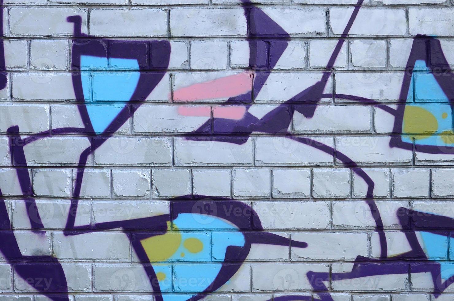 Fragment of graffiti drawings. The old wall decorated with paint stains in the style of street art culture. Colored background texture photo