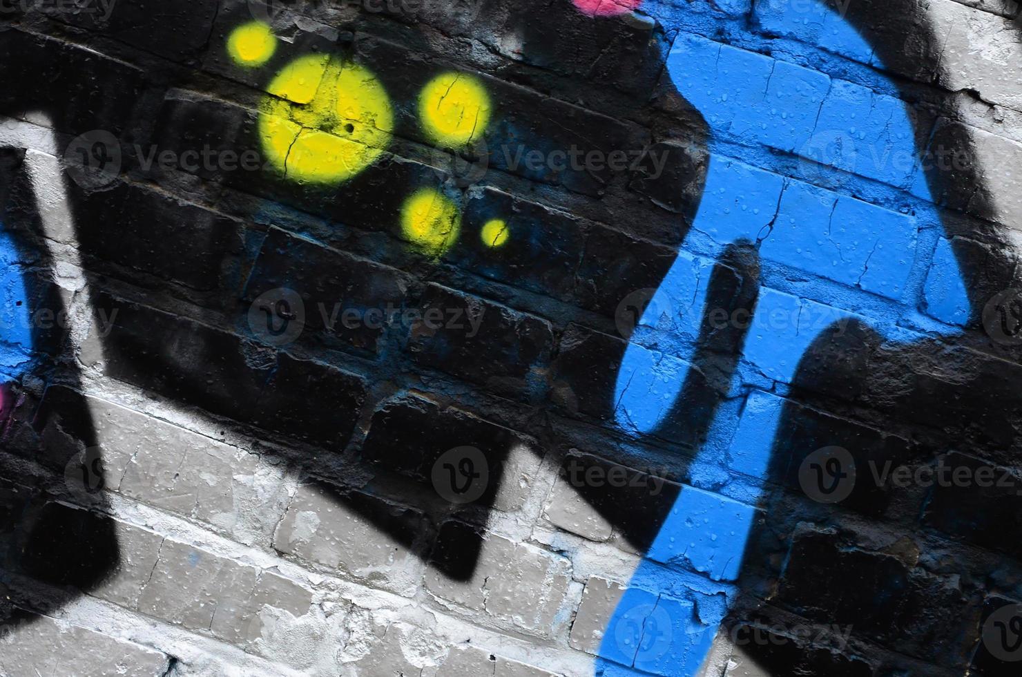 Fragment of graffiti drawings. The old wall decorated with paint stains in the style of street art culture. Colored background texture photo