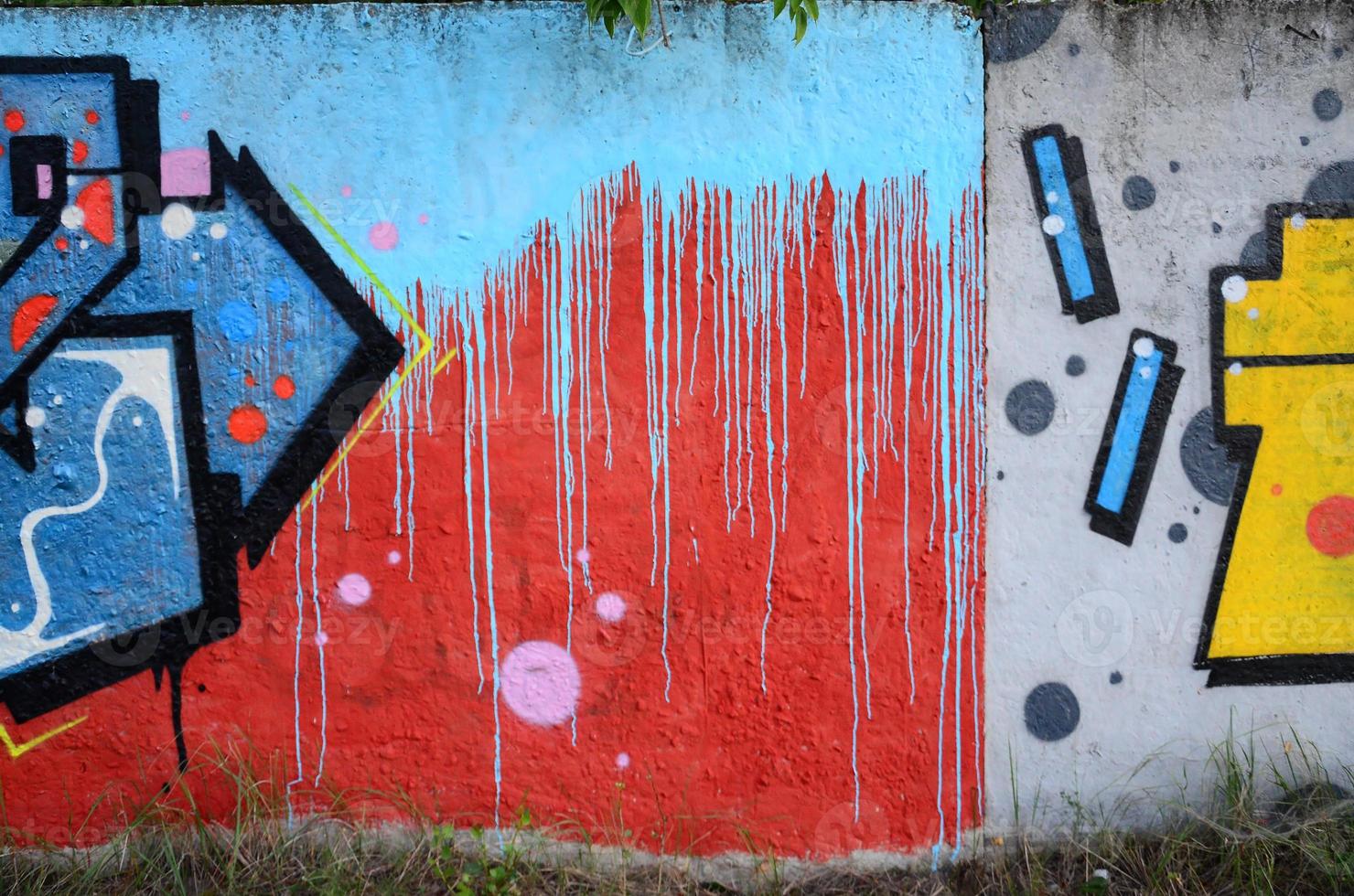 Fragment of graffiti drawings. The old wall decorated with paint stains in the style of street art culture. Colored background texture photo