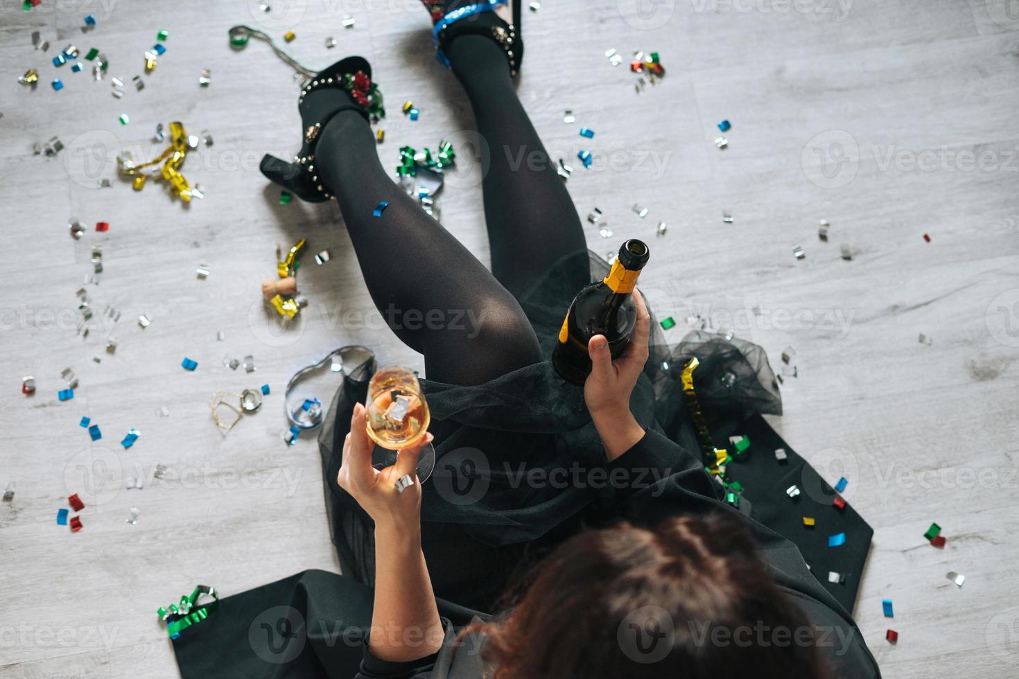 Young happy woman birthday girl forty years plus size body positive in black dress drinks champagne at the home party photo