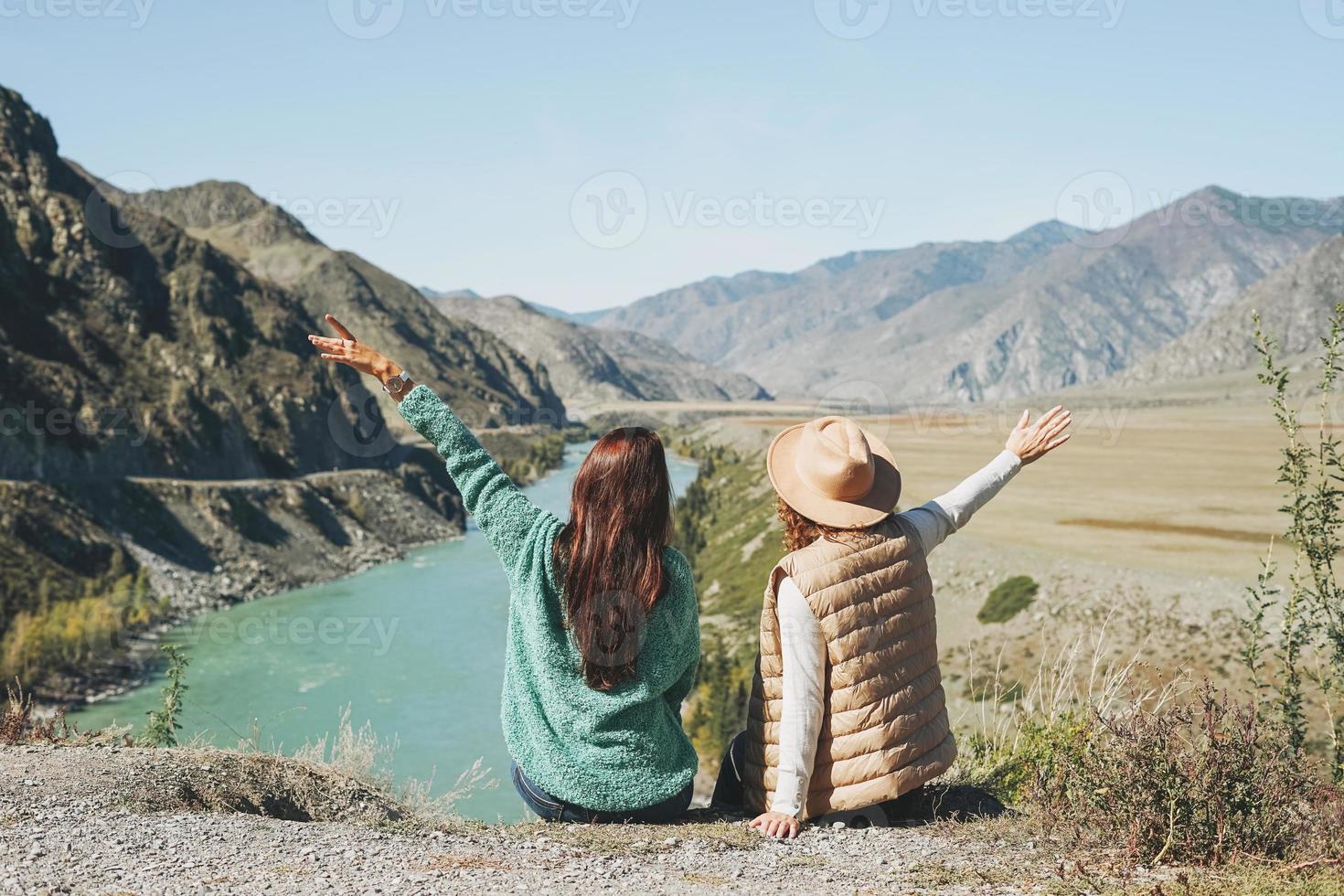 Young women travellers friends on background of the turquoise Katun river, Altai mountains photo