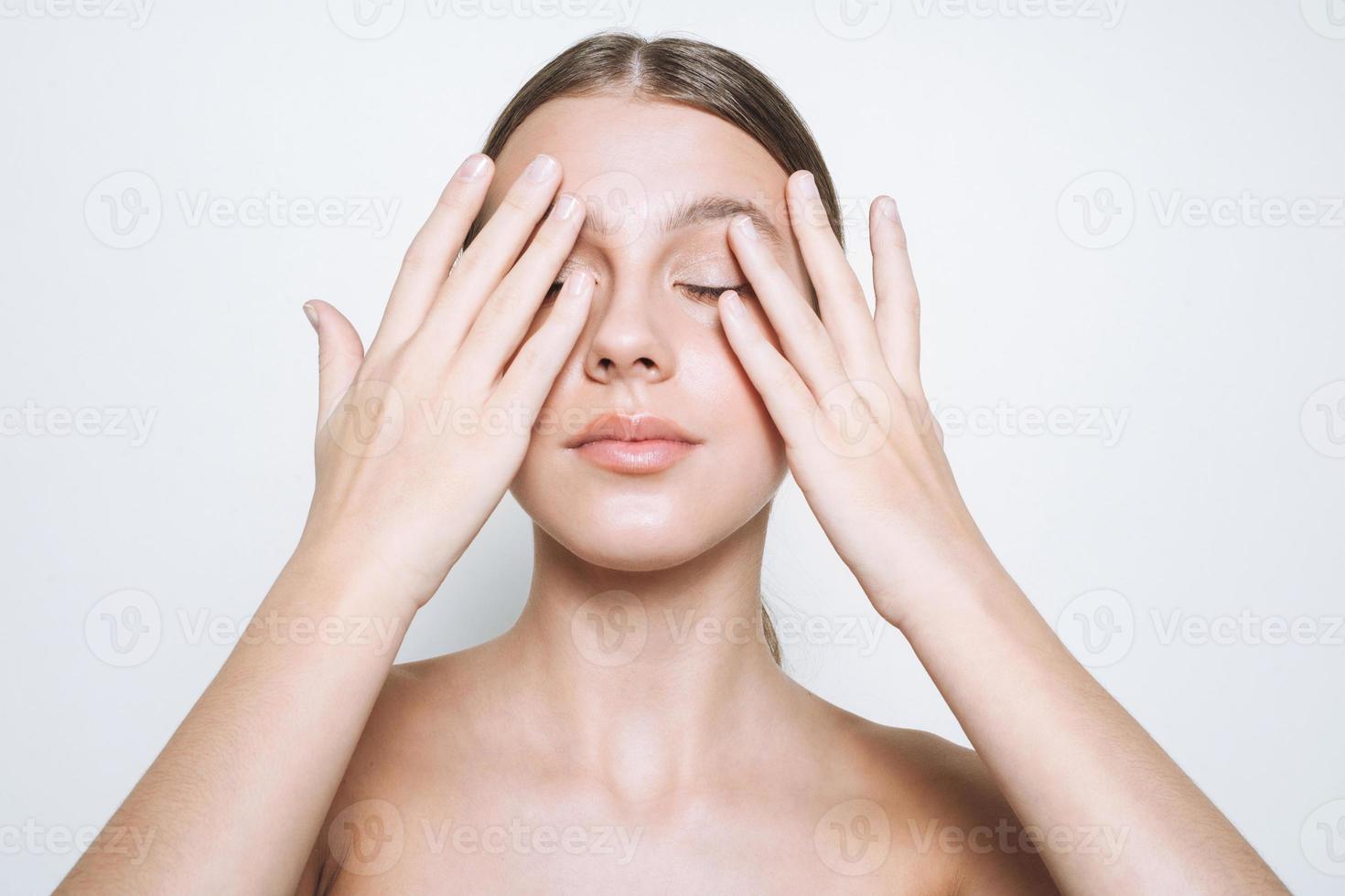 Beauty portrait of young girl with fresh skin tone, young woman with hand near face on white background isolated photo